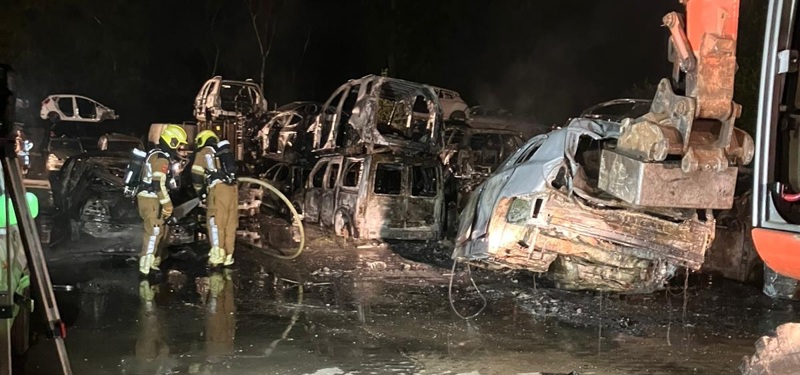 brandweer blust de stapel auto's een voor een af.