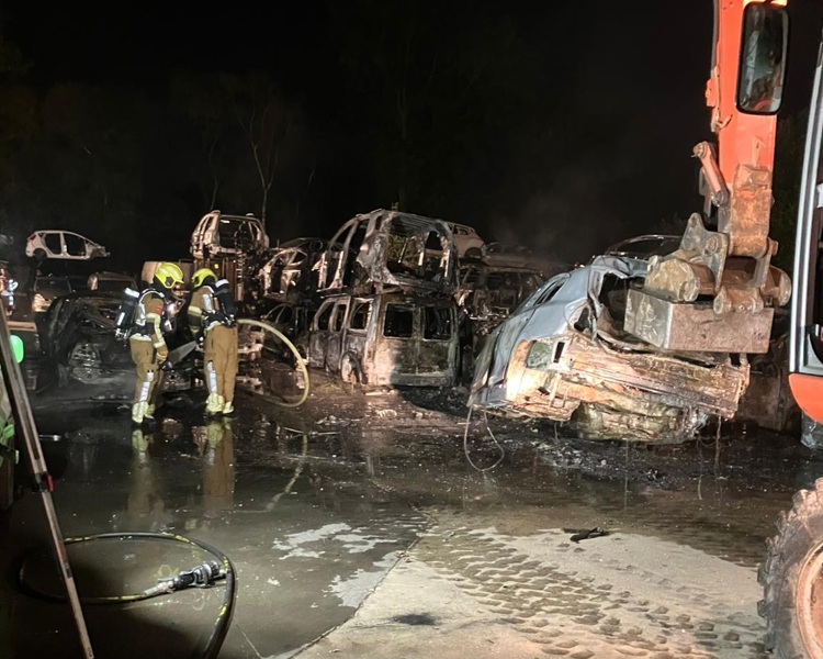 brandweer blust de stapel auto's een voor een af.