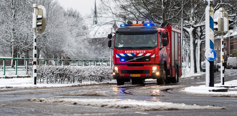 Brandweerauto rijdt door de sneeuw