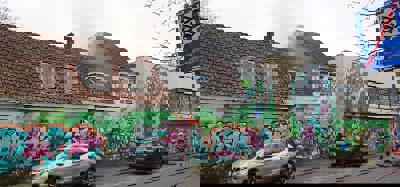 Leegstaand pand met graffiti en rookwolken uit het pand. 